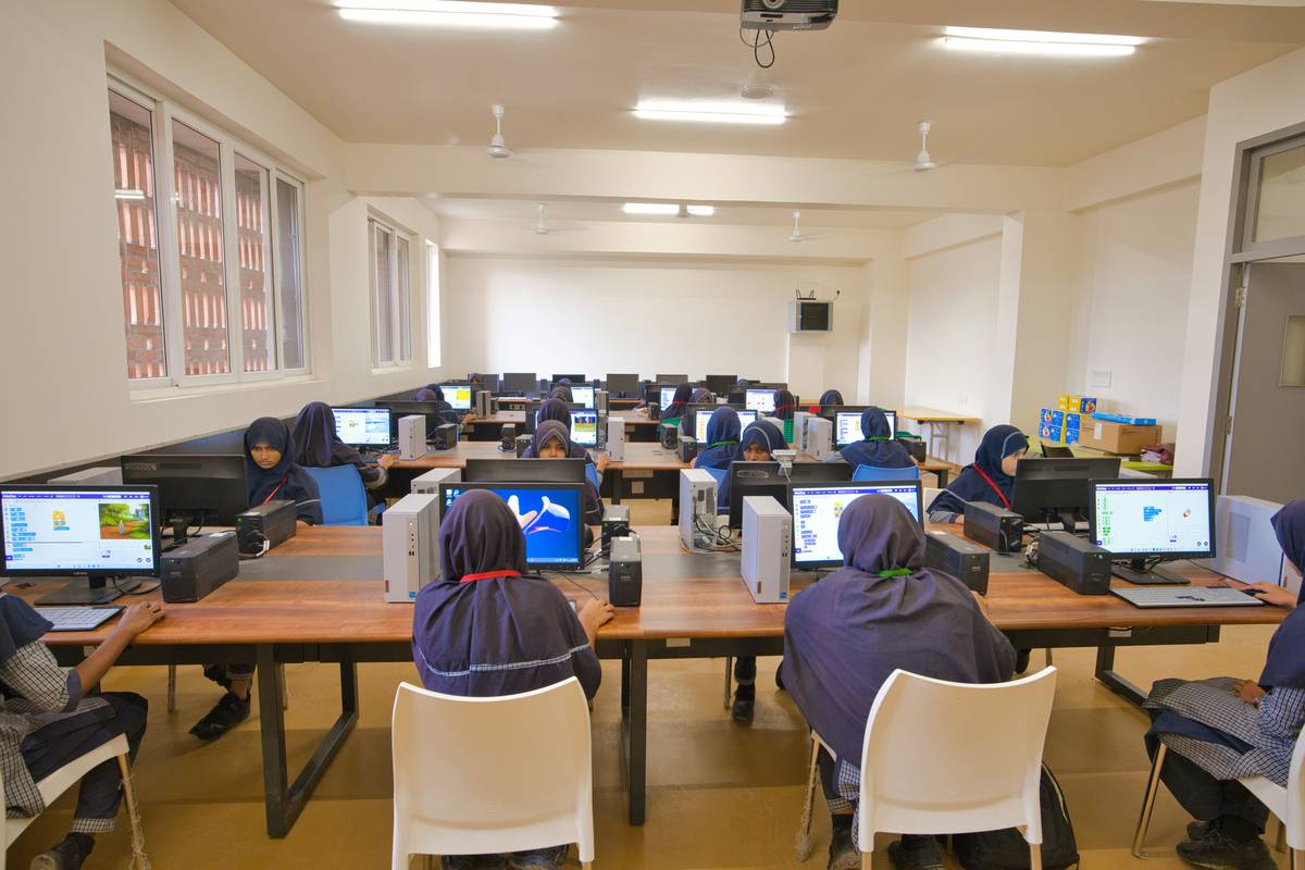 programming for robotics beginner: student testing a basic Arduino robot car with sensors on a wooden table